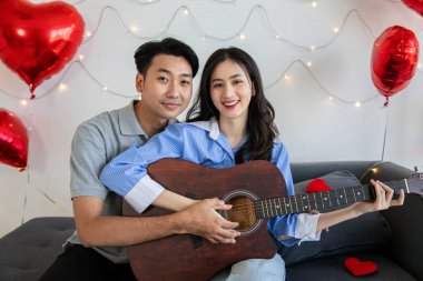 Couple of love playing on guitar for his cute lovely woman,Valentine's Day  concept.