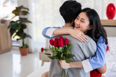 Couple in love hugging in the bedroom with rose and gift Valentine's Day  concept.