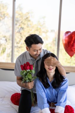 Beautiful young couple surprise with rose and gift in bedroom,Valentine's Day  concept.