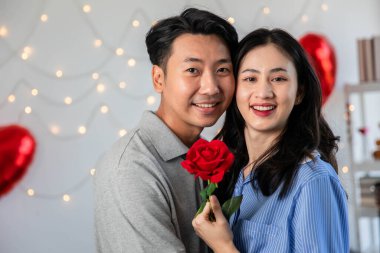 Couple in love hugging in the bedroom with rose and gift Valentine's Day  concept.