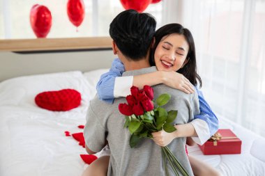 Couple in love hugging in the bedroom with rose and gift Valentine's Day  concept.