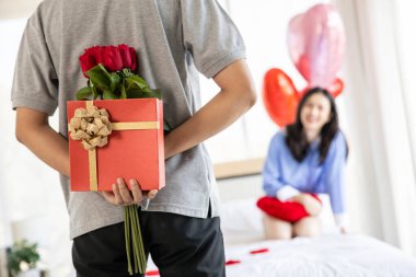 loving couple  Man with rose and gift on back in bedroom valentines day concept.
