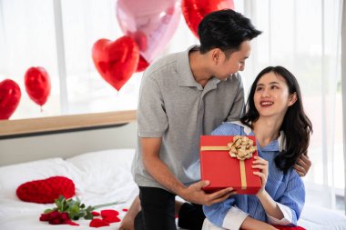 Beautiful young couple surprise with rose and gift in bedroom,Valentine's Day  concept.