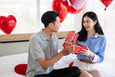 Beautiful young couple surprise with rose and gift in bedroom,Valentine's Day  concept.