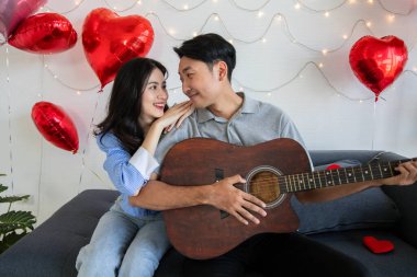 Couple of love playing on guitar for his cute lovely woman,Valentine's Day  concept.