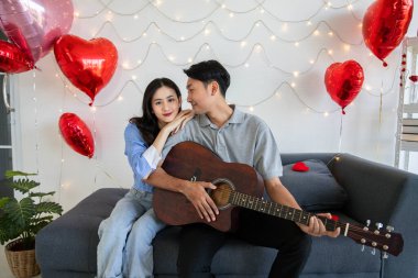 Couple of love playing on guitar for his cute lovely woman,Valentine's Day  concept.