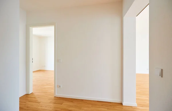 在有山毛榉地板和白墙的住宅中空的非常新的公寓 免版税图库照片