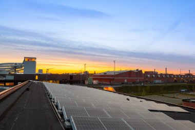 on an building in an residential area, there are solar panels on the roof on a sunny day