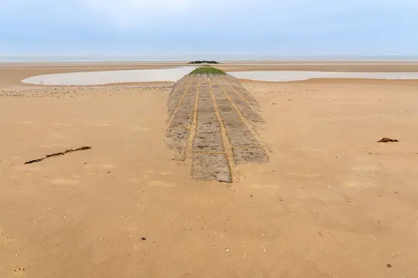 stock image On the coast there is a breakwater in the sea sand for breaking the sea