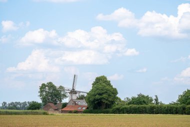 Sabahın erken saatlerinde güneşin gökyüzünde doğduğu güzel bir yel değirmeni vardır.