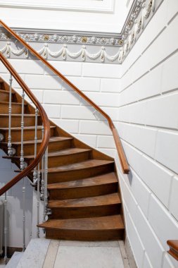 Bu mermer ve eski bir malikanede ikiye ayrılan tahta bir merdiven.