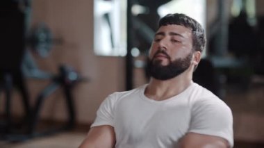 Çekici ve güçlü bir adama yakın çekim, spor salonunda özel ekipmanlarla harika ağırlıklar kaldırır. Spor salonunda güçlü bir adamı vurmak..
