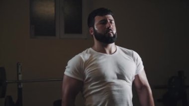 Dengeli atış ve yakın çekim. Güçlü adam antrenmanı. Beden eğitiminde kasları kasıp kasmak. Spor salonunda güçlü bir adamı vurmak..