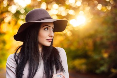 Şapkalı genç bir bayanın sonbahar fotoshoot 'u. Tarzın ve doğal dünyanın uyumlu bir karışımı..