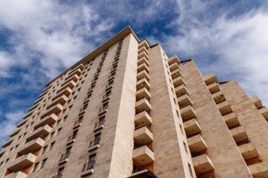 Gökyüzüne uzanan balkonları olan modern bir apartman.