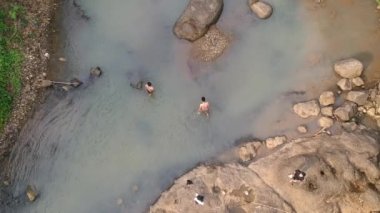 Cianjur, Batı Java, Endonezya - 24 Temmuz 2022: insanlar nehirde yıkanır
