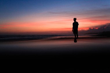 Bir erkek silueti duruyor.