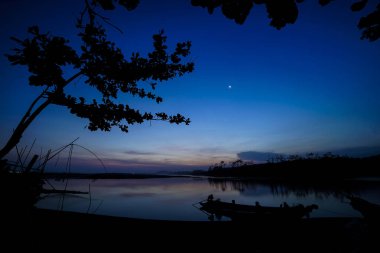 Gölde ağaç ve tekne silueti