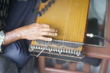 Yaşlı adamın eli Kecapi çalıyor. Orijinal Endonezya müzik enstrümanları