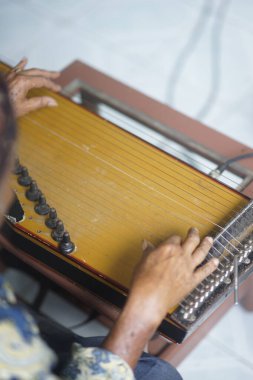 Oyuncu bir enstrüman çalıyor. Kecapi Endonezya 'dan geleneksel müzik