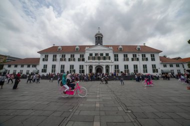 JAKARTA, INDONEZYA - 14 Ekim 2016: Kota tua Jakarta 'da bisiklet süren bir turistin atmosferi