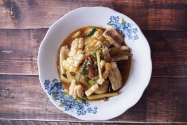 Yemek menüsü fotoğrafları için tatlı ve ekşi mürekkep balığı. Yukarıdan ahşap arkaplan resimleri çekilmiş bir restoranda.