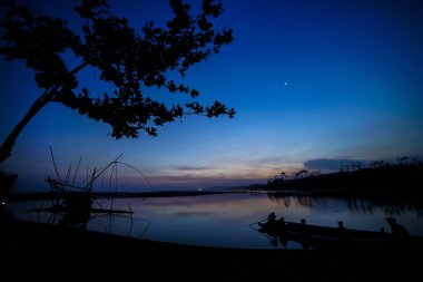 Gün batımının atmosferi balık tutma ekipmanları ve küçük teknelerle dolu.