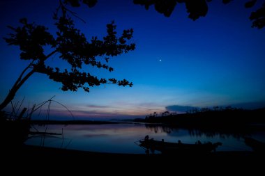 Gölde ağaç ve tekne silueti