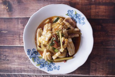 Yemek menüsü fotoğrafları için tatlı ve ekşi mürekkep balığı. Yukarıdan ahşap arkaplan resimleri çekilmiş bir restoranda.