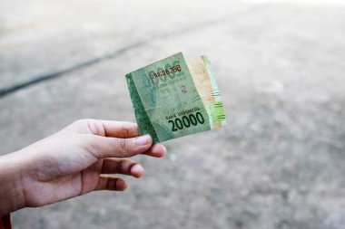 Kadın yirmi bin rupiah alıyor.