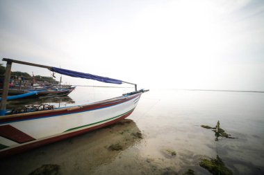 boat leaning on the beach of Ujung Genteng sukabumi Indonesia clipart