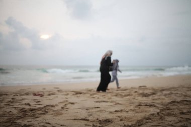 Kumsalda koşan iki kişinin bulanıklığı.