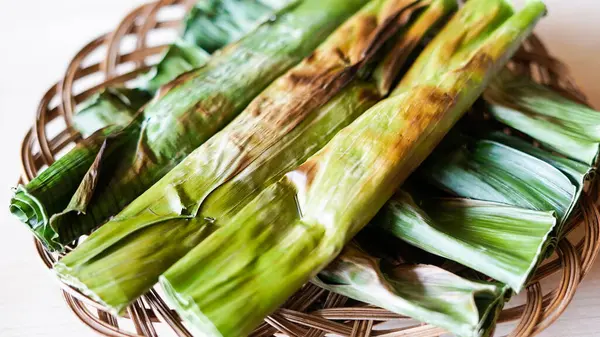 Otak otak Palembang. Geleneksel Palembang atıştırmalıkları muz yaprağıyla sarılmış ızgara balık kekleri. beyaz arkaplan