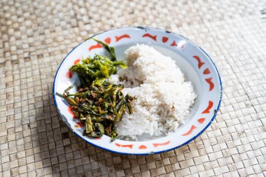 Tümör Genjer. Mayalanmış soya fasulyeli sotelenmiş sarı kadife yapraklar. Bir porsiyon yeşil biberli pilav ile servis edilir.