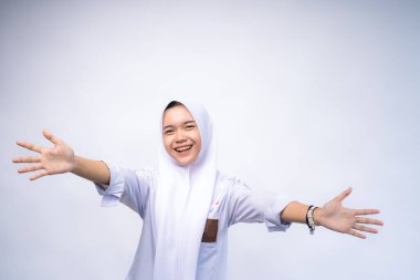 Neşeli, Asyalı, genç, Müslüman, lise üniforması giyen, kollarını açık tutan, kucaklaşmak için gülümseyen, hoş karşılayan, kucaklayan, kucaklayan,