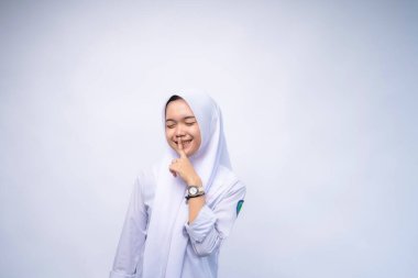 Gürültü yapmayın. Üniformalı genç kız portresi parmağını ağzında tutuyor. Eğitim kavramı