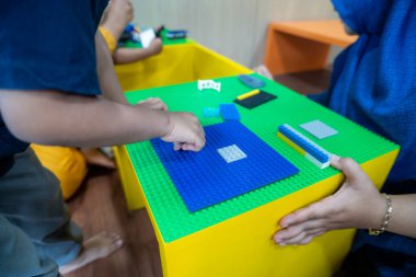 Annesiyle lego oynayan çocuğun yakın çekimi.