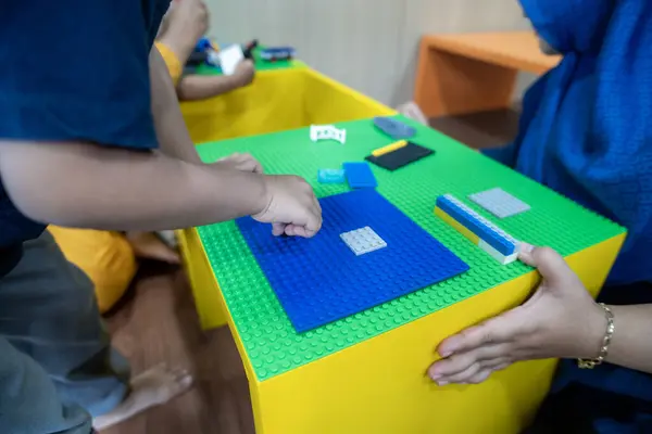 Annesiyle lego oynayan çocuğun yakın çekimi.
