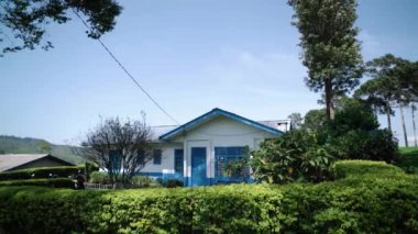 CIWIDEY, İNDONEZYA - 30 Ekim 2024: Gün boyunca doğal atmosferi olan mavi ve beyaz çay toplayıcıları evleri