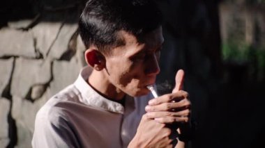 CIANJUR, İNDONEZYA - 25 EKİM 2024: bir adam sigara içiyor. Tecrübeli bir sigara tiryakisi. Bu sağlığın için kötü. Sorunlar ve depresyon