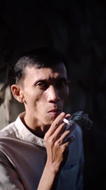 CIANJUR, İNDONEZYA - 25 EKİM 2024: bir adam sigara içiyor. Tecrübeli bir sigara tiryakisi. Bu sağlığın için kötü. Sorunlar ve depresyon
