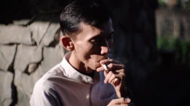 CIANJUR, İNDONEZYA - 25 EKİM 2024: bir adam sigara içiyor. Tecrübeli bir sigara tiryakisi. Bu sağlığın için kötü. Sorunlar ve depresyon