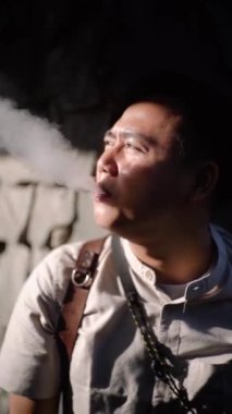 CIANJUR, İNDONEZYA - 25 EKİM 2024: Bir adam elektronik sigara içiyor