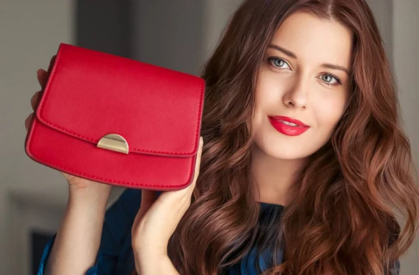 Fashion and accessories, happy beautiful woman holding small red handbag with golden details as stylish accessory and luxury shopping concept