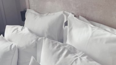 Ev dekorasyonu ve iç dekorasyon, lüks yatak odasındaki beyaz yatak odası, çarşaf yıkama ve mobilya işleri. Yüksek kalite 4k görüntü