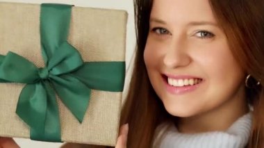 Kış tatili, hediye ve mutlu noeller, gülümseyen ve paketlenmiş hediye kutusu tutan mutlu bir kadın. Yüksek kalite 4k görüntü