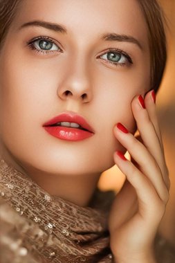Güzellik, makyaj ve cazibe, manikür ve kırmızı rujlu güzel bir kadının yüz portresi lüks kozmetik, tarz ve moda için altın rengi giyiyor.