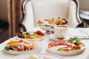 Lüks otel ve beş yıldızlı oda servisi, çeşitli yemek tabakları, ekmek ve kahve seyahat ve konukseverlik markası olarak oda kahvaltısı.