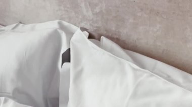 Ev dekorasyonu ve iç dekorasyon, lüks yatak odasındaki beyaz yatak odası, çarşaf yıkama ve mobilya işleri. Yüksek kalite 4k görüntü