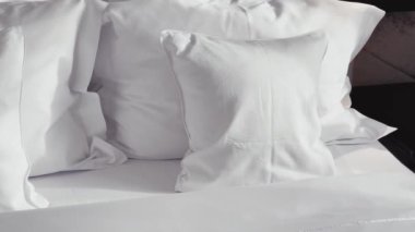 Ev dekorasyonu ve iç dekorasyon, lüks yatak odasındaki beyaz yatak odası, çarşaf yıkama ve mobilya işleri. Yüksek kalite 4k görüntü